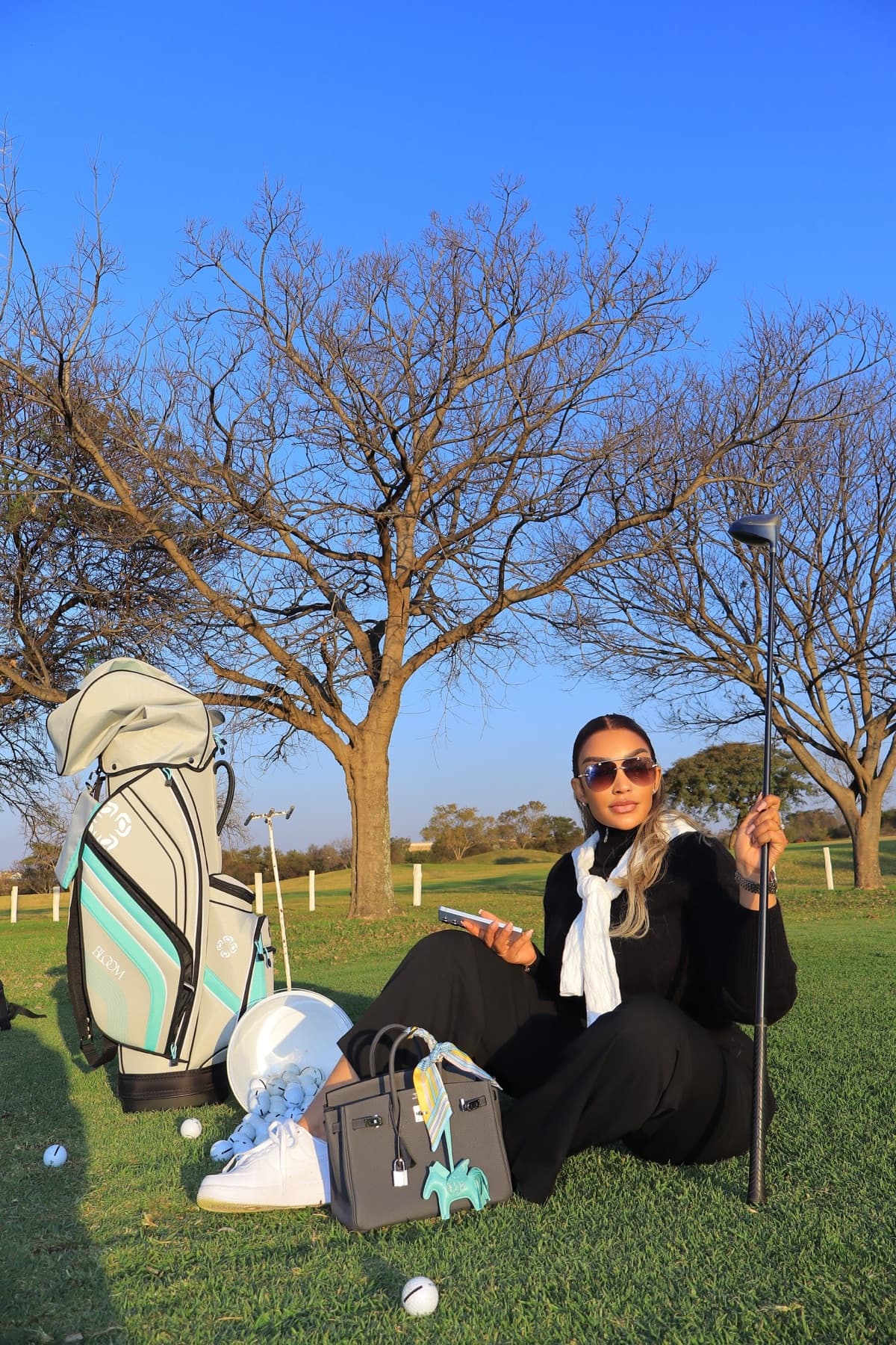 Zari relaxing on the course with club in hand
